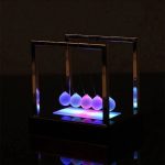 Moderne Newton-Kugel mit leuchtenden Kugeln und LED-Beleuchtung, ideal für wissenschaftliche Dekorationen und als faszinierendes Lehrmittel.