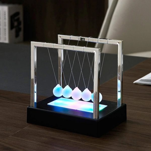 Dekoratives Newton-Wiege-Objekt mit LED-Beleuchtung, ideal für Wissenschafts- und Dekorationszwecke, auf einem dunklen Tisch präsentiert.