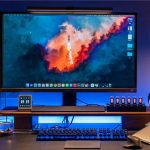 Hochauflösender Computerbildschirm mit Weltraum- und Raketenmotiven, ergänzt durch eine Tastatur, Maus und dekorative Elemente auf einem Schreibtisch.