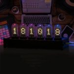 Moderne Nixie-Uhr mit leuchtenden Zahlen, die auf einem Tisch mit Musik- und Computerausrüstung im Hintergrund steht, ideal für Technik- und Wissenschaftsbegeisterte.