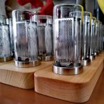 Mehrere wissenschaftliche Glasbehälter mit Metall-Design auf Holzunterlage, ideal für Dekorationen und Gadgets im wissenschaftlichen Stil.