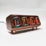 Vintage Nixie-Uhr mit Holzgehäuse, zeigt numerische Zeit mit leuchtenden Glührohren, stilvoll und retro-inspiriert, ideal für Technik- und Designliebhaber.