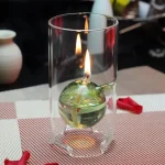 Glas mit Wasserball, in dem eine Flamme brennt, als wissenschaftliches Dekorationsstück.