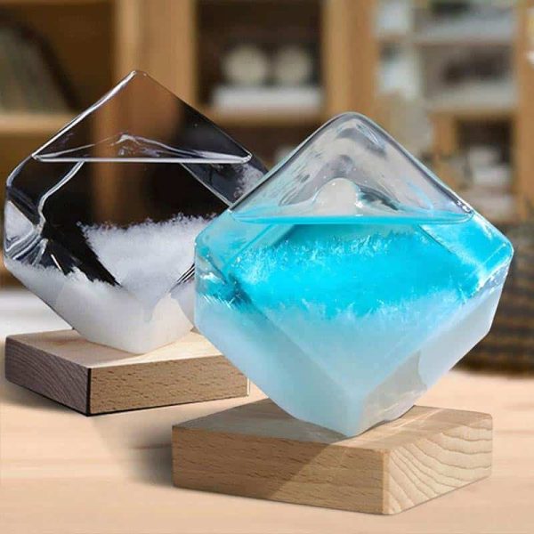 Zwei dekorative Kristall-Objekte aus Glas, eines mit weißem, das andere mit bläulichem Inhalt, auf Holzständern, ideal für wissenschaftliches Dekor und moderne Inneneinrichtung.