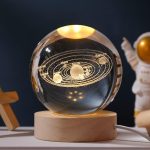 Dekorativer Globus mit Solar-System-Design, der die Planeten und ihre Umlaufbahnen in einem stilvollen, beleuchteten Kristallkugel zeigt.
