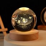 Dekorativer Sternenprojektor mit Solar-System-Modell, das auf einer Holzbasis leuchtet, ideal für wissenschaftliche Dekorationen und Lernzwecke.