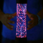 Plasma-Lampe mit leuchtenden Blitzen, die in einem dunklen Raum zwischen den Händen gehalten wird, zeigt elektrische Entladungen in einem transparenten Zylinder.