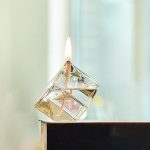 Ein brennender Würfel aus transparentem Material mit sichtbarer Flamme auf einer glatten Oberfläche, geeignet für wissenschaftliche Experimente und Dekoration.