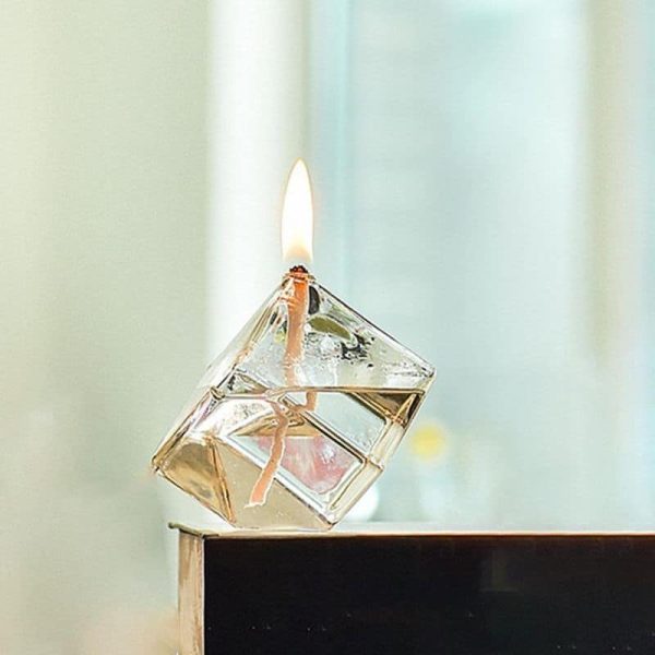 Ein brennender Würfel aus transparentem Material mit sichtbarer Flamme auf einer glatten Oberfläche, geeignet für wissenschaftliche Experimente und Dekoration.