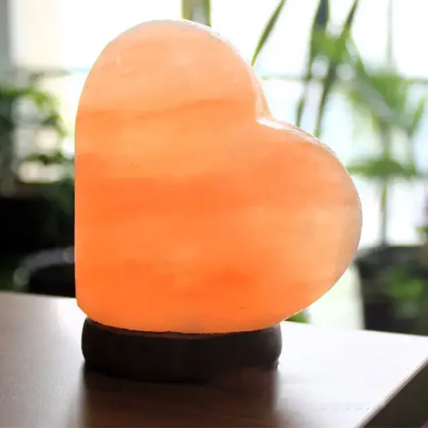 Herzförmiger Leuchtstein aus Salz, der warmes Licht ausstrahlt, ideal für Dekoration und romantische Atmosphäre.