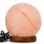 Atmosphärische Steinklampfe mit warmem Licht, auf Holzsockel, ideal für Dekoration und Entspannung.