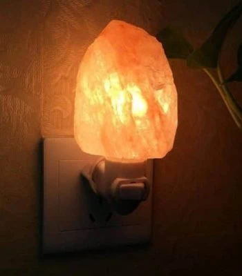 Salzlampe, die an eine Steckdose angeschlossen ist, sorgt für warmes, beruhigendes Licht in einem Raum. Perfekt für eine entspannte Atmosphäre und dekoratives Element.