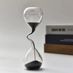 Dekoratives Sanduhr-Design mit schwarzem Sand für Wissenschafts- und Dekorationsliebhaber.