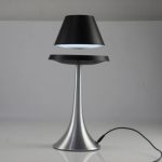 Elegante Tischlampe mit schwarzem Lampenschirm und silbernem Sockel, ideal für moderne Wohnräume und Büros.