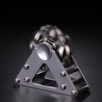 Ein metallischer Kugel-Generator mit beweglichen Kugeln, der auf einer stabilen Metallbasis steht, ideal für wissenschaftliche Demonstrationen und Dekorationen.