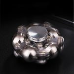 Metallischer Schwerkraft-Spinner in Bewegung, zeigt dynamische Rotation auf schwarzem Hintergrund. Perfekt für Wissenschafts- und Dekorationszwecke.