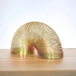 Metallspirale in Schneckenform, dekoratives wissenschaftliches Kunstobjekt auf Holzplatte, modernes Design, ideal für Wissenschafts- und Dekorationsliebhaber.