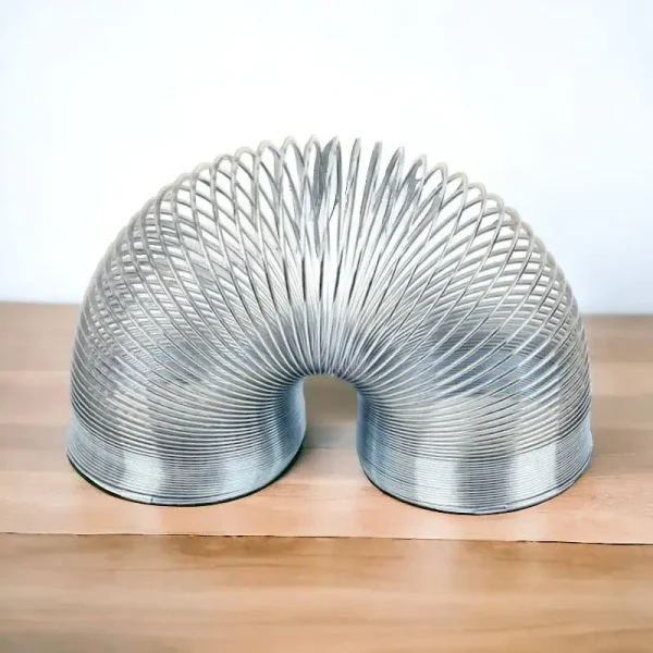 Metallischer wissenschaftlicher Gegenstand in einer spiralförmigen Form, ideal für Dekoration und Gadgets, auf Holzoberfläche präsentiert.