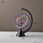 Leuchtendes kinetisches Kunstwerk mit bunten Neonlichtern, das auf einem schwarzen Standfuß steht. Das Design zeigt rotierende, leuchtende Ringe in verschiedenen Farben, ideal als wissenschaftliche De.