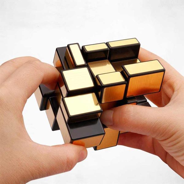 Hand hält einen komplexen, mehrfarbigen Rätselwürfel, der zum Lösen und Spielen gedacht ist, mit einem weißen Hintergrund.