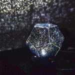 Sternenprojektor in Form eines geometrischen Kristalls, der funkelnde Lichtmuster an die Wand wirft, ideal für Dekoration und wissenschaftliche Präsentationen.