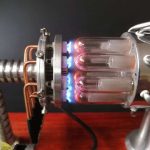 Detailliertes Bild eines wissenschaftlichen Apparats mit Glaskolben, der durch eine blaue Flamme erhitzt wird, ideal für wissenschaftliche Demonstrationen und Experimente.
