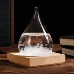 Ein Glas mit einer chemischen Reaktion, die Blasen und Schaum erzeugt, steht auf einem Holzsockel. Das Bild zeigt ein wissenschaftliches Experiment oder Dekorationsobjekt.