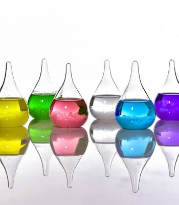 Sechs bunte chemische Reagenzgläser mit unterschiedlichen Flüssigkeiten, reflektiert auf einer glatten Oberfläche, symbolisieren Wissenschaft und Forschung.