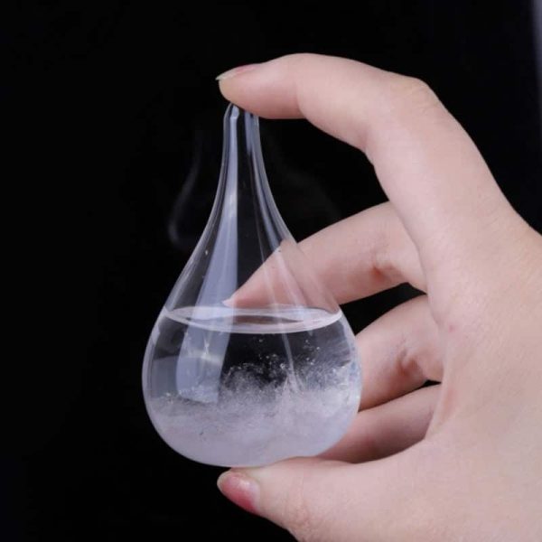 Hand hält eine kleine, transparente Glasflasche mit Dampf und Wasser, ideal als wissenschaftliches Dekorationsstück oder Lehrmaterial.