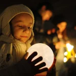 Junge hält eine leuchtende Kugel, die den Mond darstellt, bei Nacht, umgeben von anderen leuchtenden Figuren, ideal für wissenschaftliche Dekorationen.