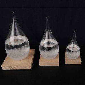 Drei Glasampullen mit Wasser auf Holzbasen, die unterschiedliche Größen haben, zeigen ein wissenschaftliches Experiment zur Wasserreflexion und -brechung.