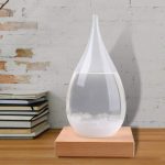 Elegante Wassertropfen-Dekoration aus Glas auf Holzsockel, ideal für wissenschaftliche oder dekorative Zwecke.