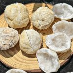 Natürliche Steine und Kristalle auf Holzschale, ideal für wissenschaftliche Dekorationen und Sammlungen.