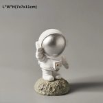 Kleines Astronauten-Sammlerstück mit Helm und Raumanzug, auf einem Felsen stehend.