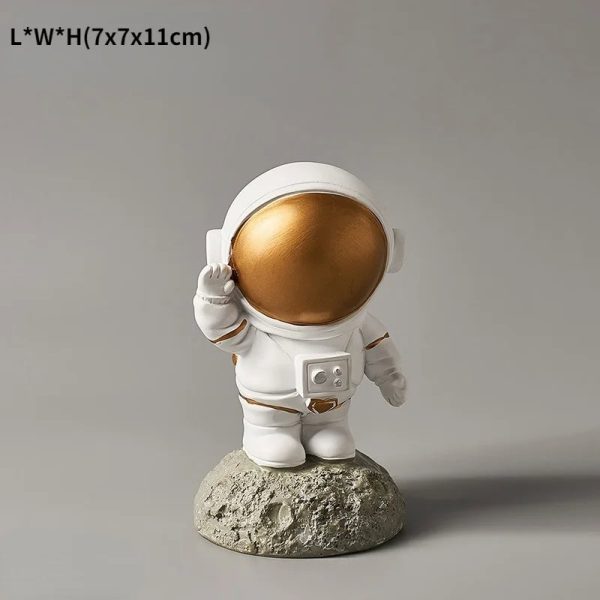 Kleiner Astronauten-Statue mit goldfarbenem Helm, stehend auf einem Mond-ähnlichen Felsen, ideal für Wissenschafts- und Dekorationszwecke.
