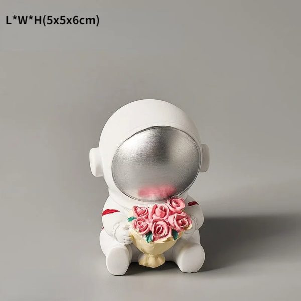 Niedliche Astronautenfigur mit silbernem Helm, die einen Blumenstrauß aus rosa Rosen hält, ideal als Dekoration oder Geschenk für Wissenschafts- und Raumfahrtliebhaber.