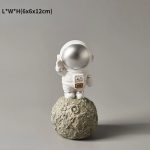 Kleine Astronautenfigur auf einer Mondlandschafts-Statue, ideal als wissenschaftliches Dekor oder Sammlerstück. Perfekt für Weltraum- und Wissenschaftsbegeisterte.
