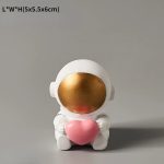 Niedlicher wissenschaftlicher Dekorationsartikel in Form eines kleinen Astronauten, der ein rosa Herz hält, ideal für Wissenschafts- und Dekorationsliebhaber.