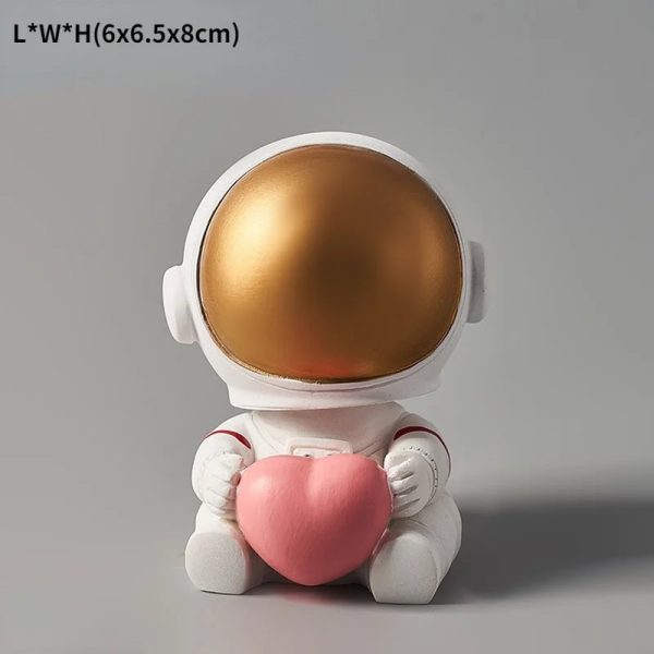 Niedliche Astronautenfigur mit goldenem Helm, die ein rosa Herz hält, ideal für Science-Fiction- und Weltraum-Dekorationen.