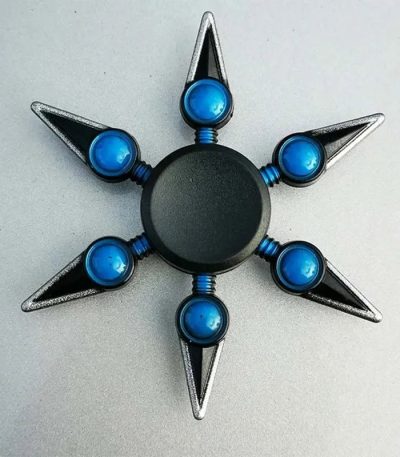 Moderner Sternförmiger Fidget Spinner mit blauen Kugeln und Metallspitzen, ideal für Stressabbau und Konzentration.