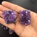 Natürliche Amethist Kristalle in Hand, detailreiche violette Mineralien, ideal für Dekoration und wissenschaftliche Sammlungen.