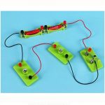 Interaktives Elektro-Experimentierset mit bunten Komponenten auf grünem Basis, ideal für Kinder zum Lernen von Stromkreisen und Elektronik.