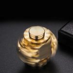 Ein goldfarbenes, rotierendes Wissenschaftsspielzeug auf schwarzem Hintergrund, das die Bewegung und Dynamik physikalischer Prinzipien zeigt.