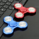 Fidget-Spielzeug in Rot und Blau auf Tastatur, ideal für Stressabbau und Konzentration.