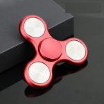 Roter Metall-Fidget-Spinner mit drei Armen, ideal für Stressabbau und Konzentrationsförderung, auf dunklem Hintergrund.
