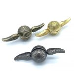 Drei Schlüsselanhänger mit Flügel-Design in Gold, Silber und Schwarz, inspiriert von wissenschaftlichen und dekorativen Elementen, ideal für Sammler und Wissenschaftsbegeisterte.
