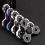 Hochwertiger Fidget Spinner in Schwarz, Weiß und bunten Farben, ideal für Stressabbau und Konzentration, auf dunklem Hintergrund.