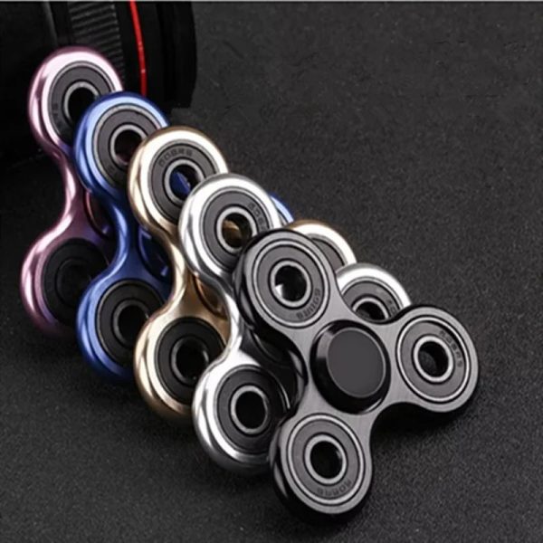 Hochwertiger Fidget Spinner in Schwarz, Weiß und bunten Farben, ideal für Stressabbau und Konzentration, auf dunklem Hintergrund.