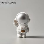 Kleiner Astronautenfigur aus Keramik mit silbernem Helm, ideal als wissenschaftliches Dekorationsstück oder Geschenk.