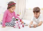 Zwei Kinder spielen mit einem pinken, intelligenten Roboter, der leuchtende Augen hat, im hellen Kinderzimmer. Perfektes pädagogisches Spielzeug für neugierige kleine Forscher.